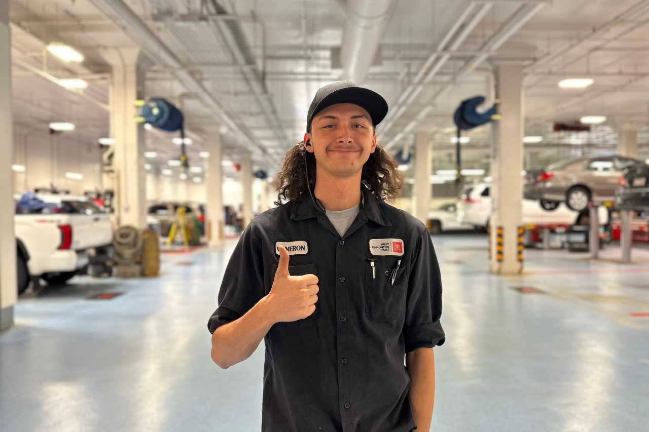 A car mechanic from the Toyota Service team gives a thumbs-up.