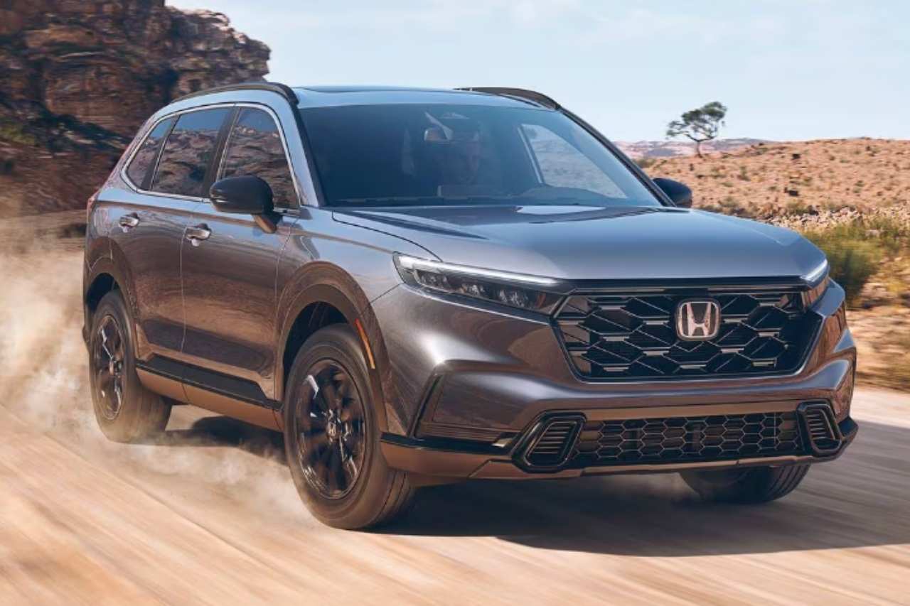 A 2024 Honda CR-V in grey is driving down a dusty desert road.