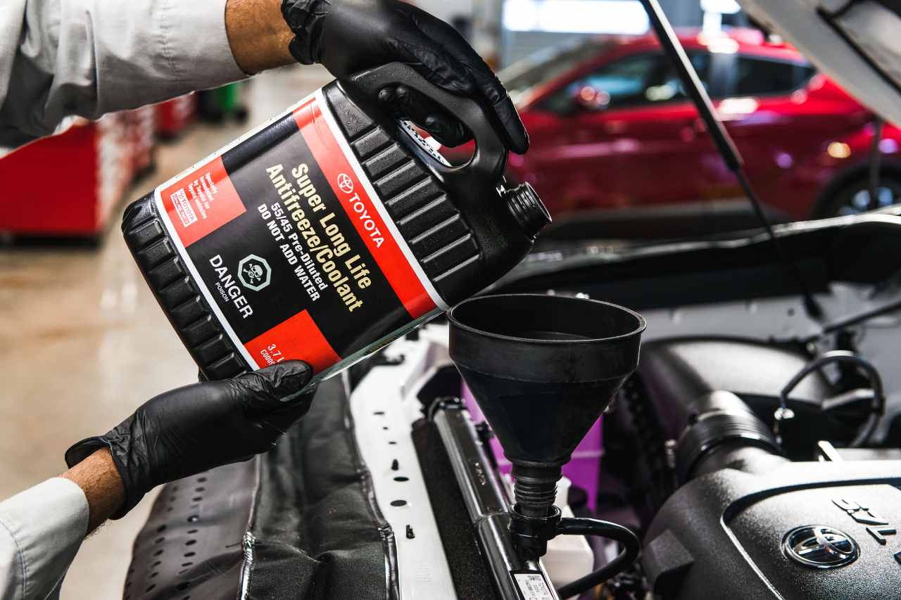 A Service technician powers Toyota Genuine Parts coolant into a vehicle in the service centre.