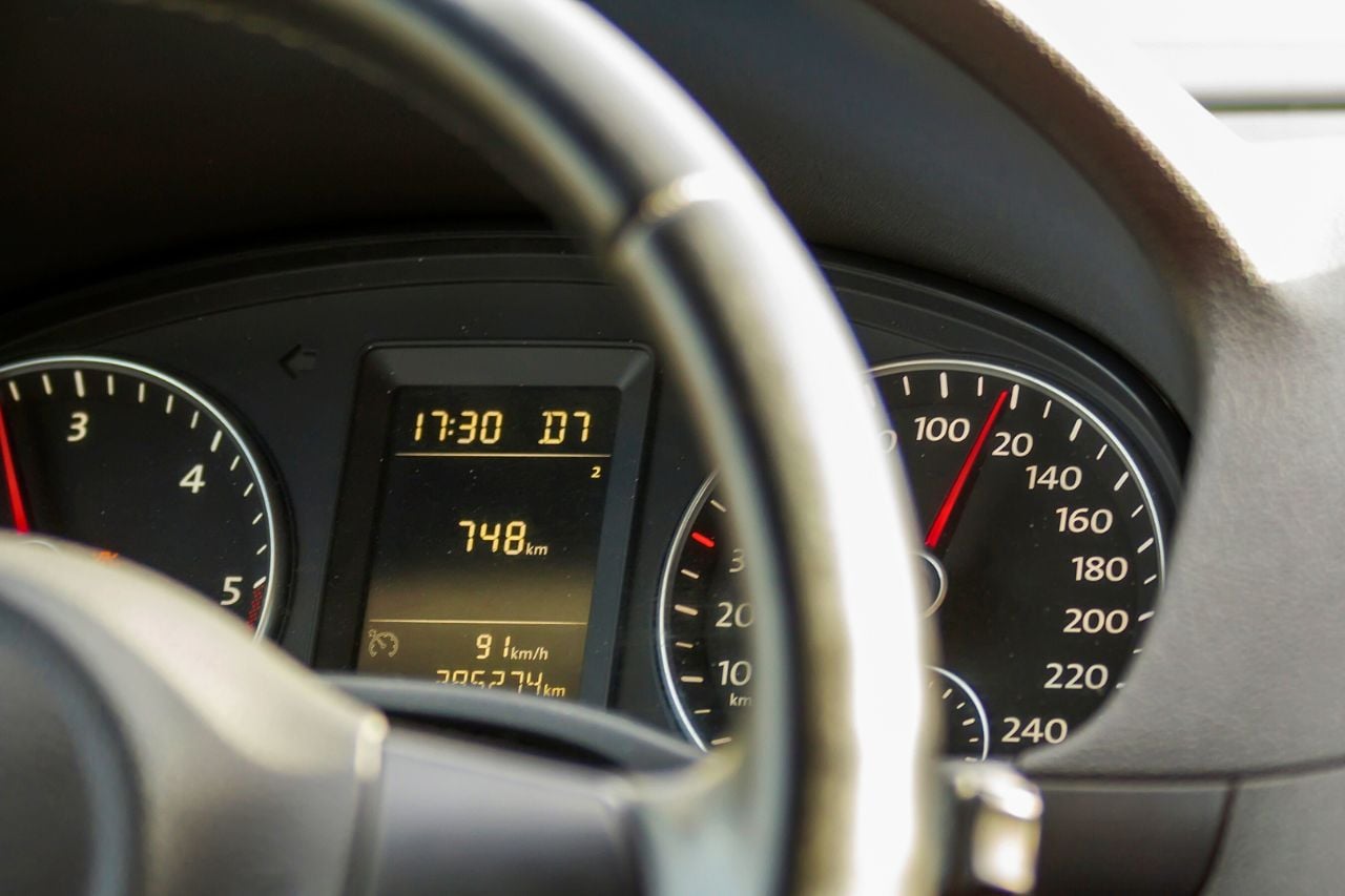A close-up of a vehicle's odometer and speedometer, showing its mileage.