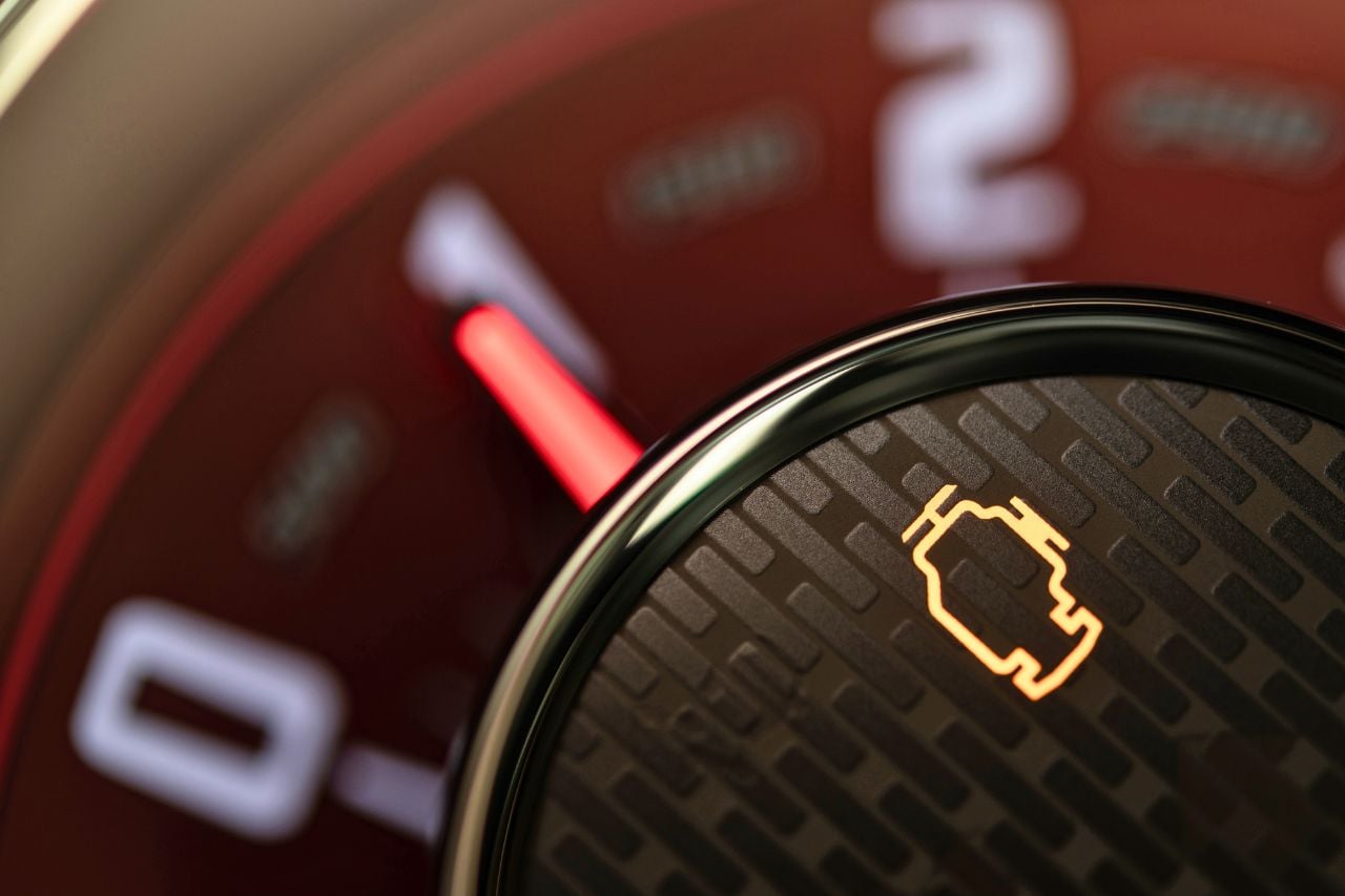 A close-up of the 'check engine' light in a vehicle. Fixing an engine issue is one of our tips to prepare your car for a trade-in.