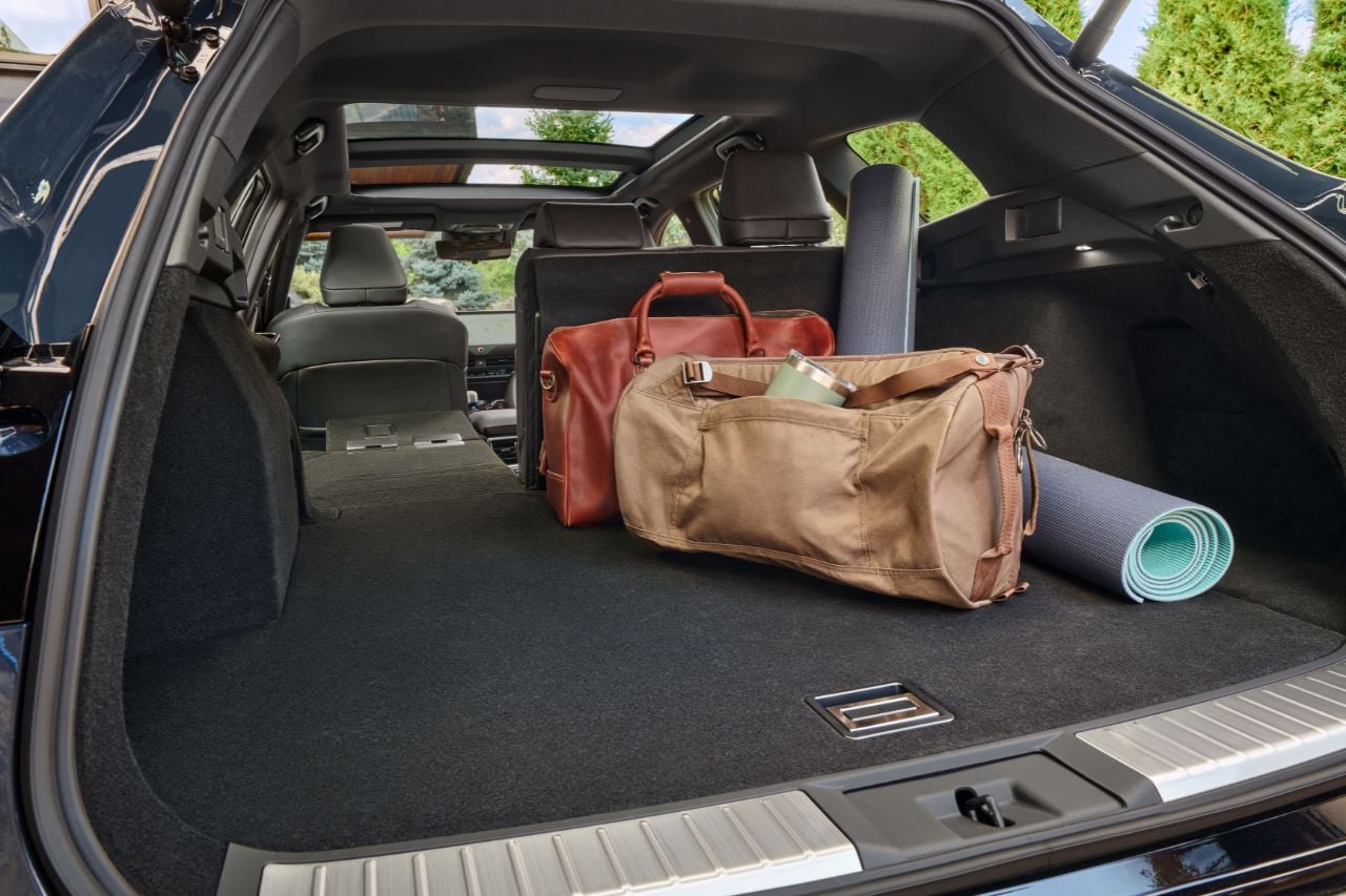 The back of the Toyota Crown Signia SUV, showing its expansive cargo area with a few placed bags of luggage.