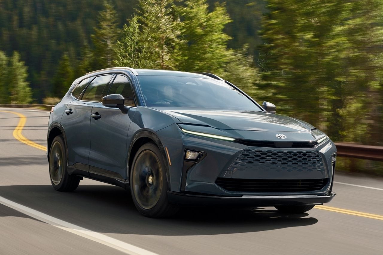 A dark grey Toyota SUV drives down a sunny highway.