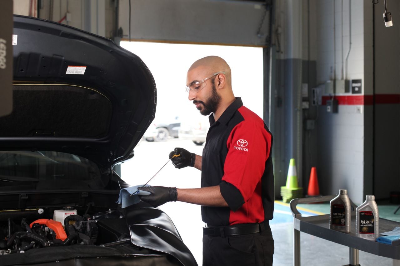 A Toyota service technician performs a routine service appointment and oil change on a vehicle at West Edmonton Mall Toyota.