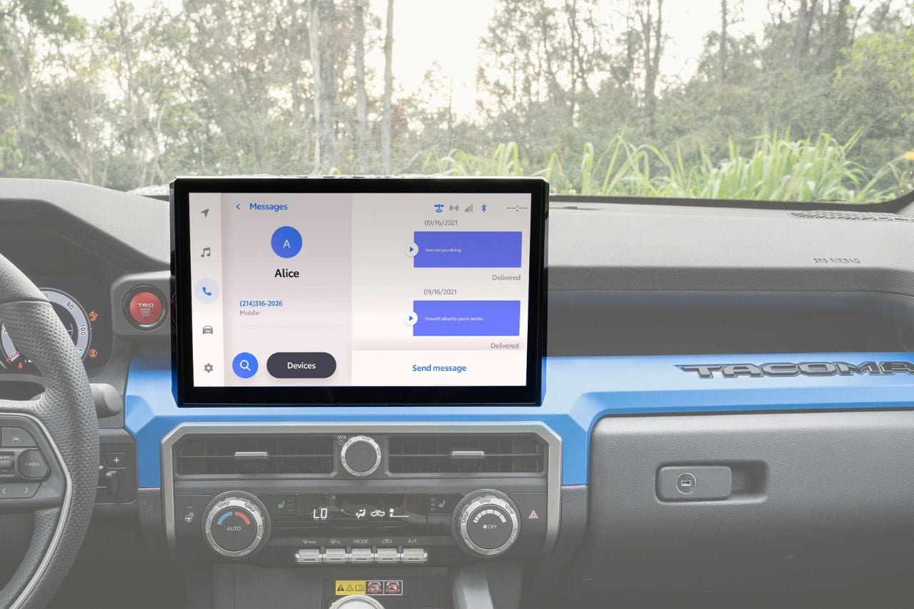 An interior look at the 2025 Toyota Tacoma truck cabin, showing a digital touchscreen system connected to a phone's messaging service.