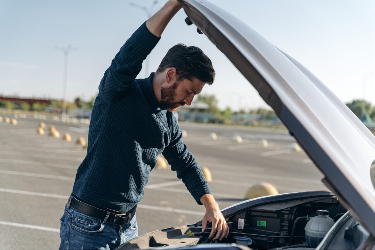 a man checking his engine in the road side