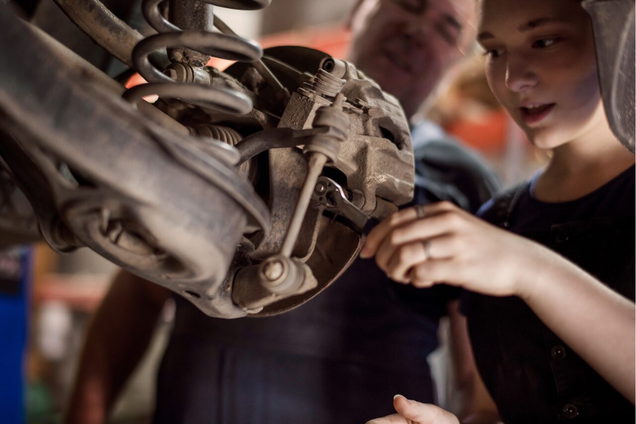 two technicians inspecting brakes