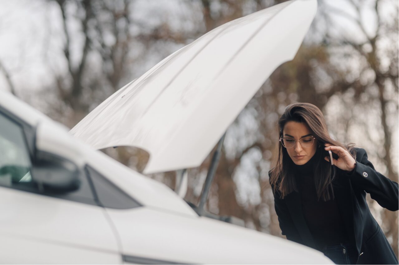 a woman calling for help while checking engine