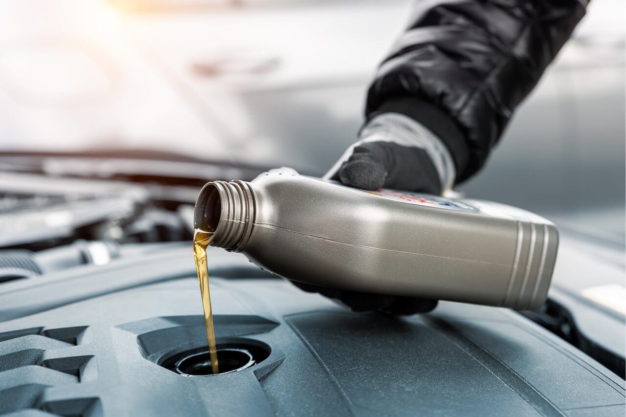 closeup of technician putting oil into the vehicle